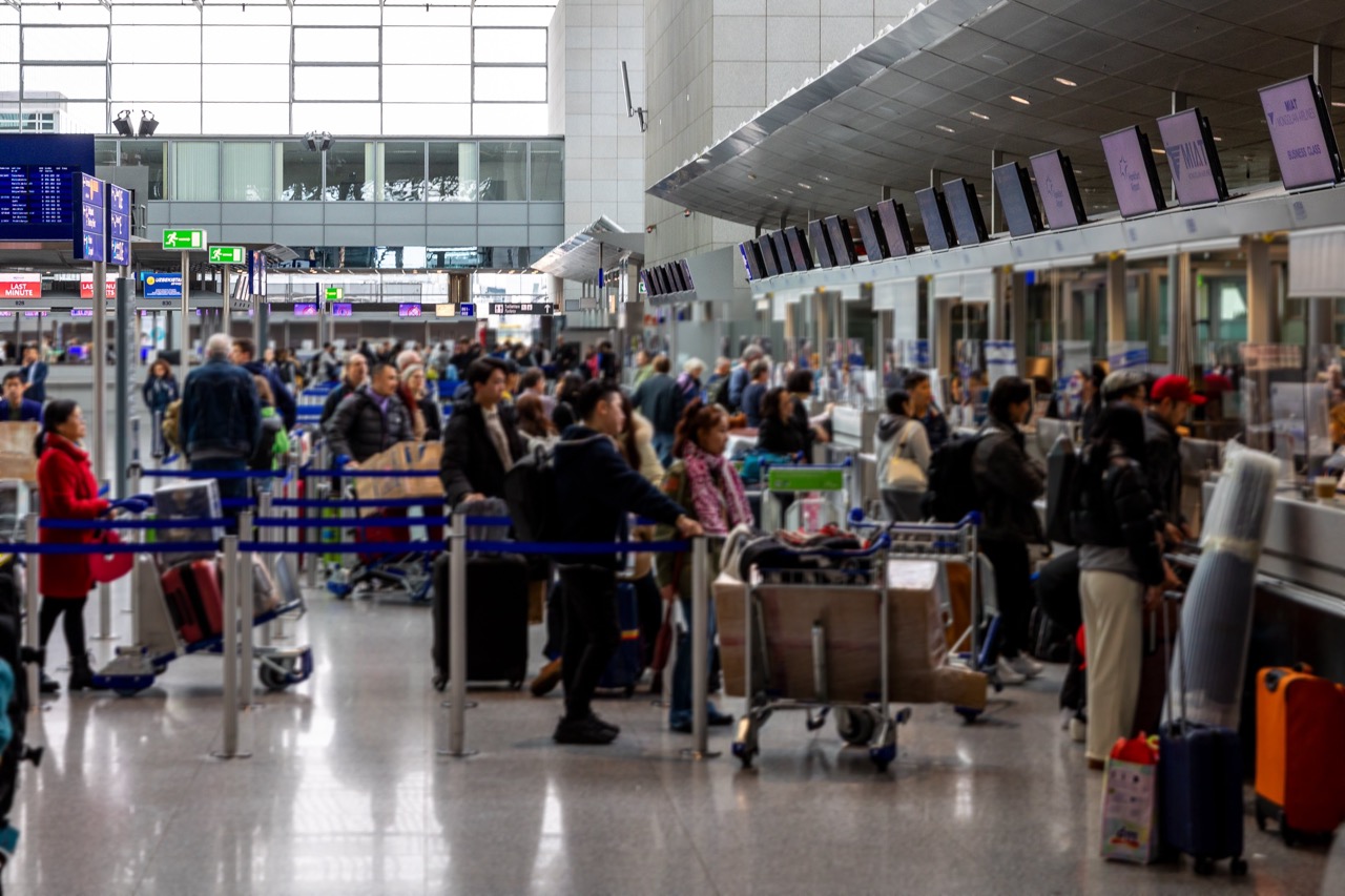 frankfurt airport germany - february 19 2024 busy airport check-in counter with travelers and luggage
